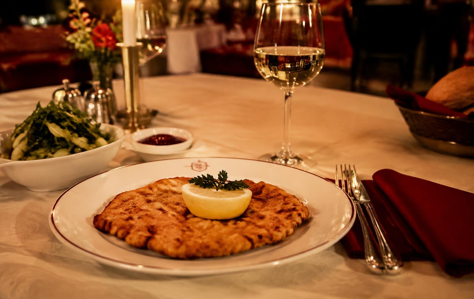 Wiener Schnitzel mit Weißwein in einem eleganten Wiener Restaurant
